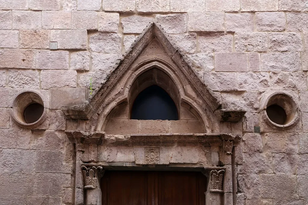 Arco sagomato e aperture circolari sopra il portale di San Domenico