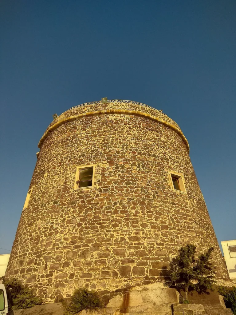 La superficie in pietra della Torre Sabauda illuminata di sera